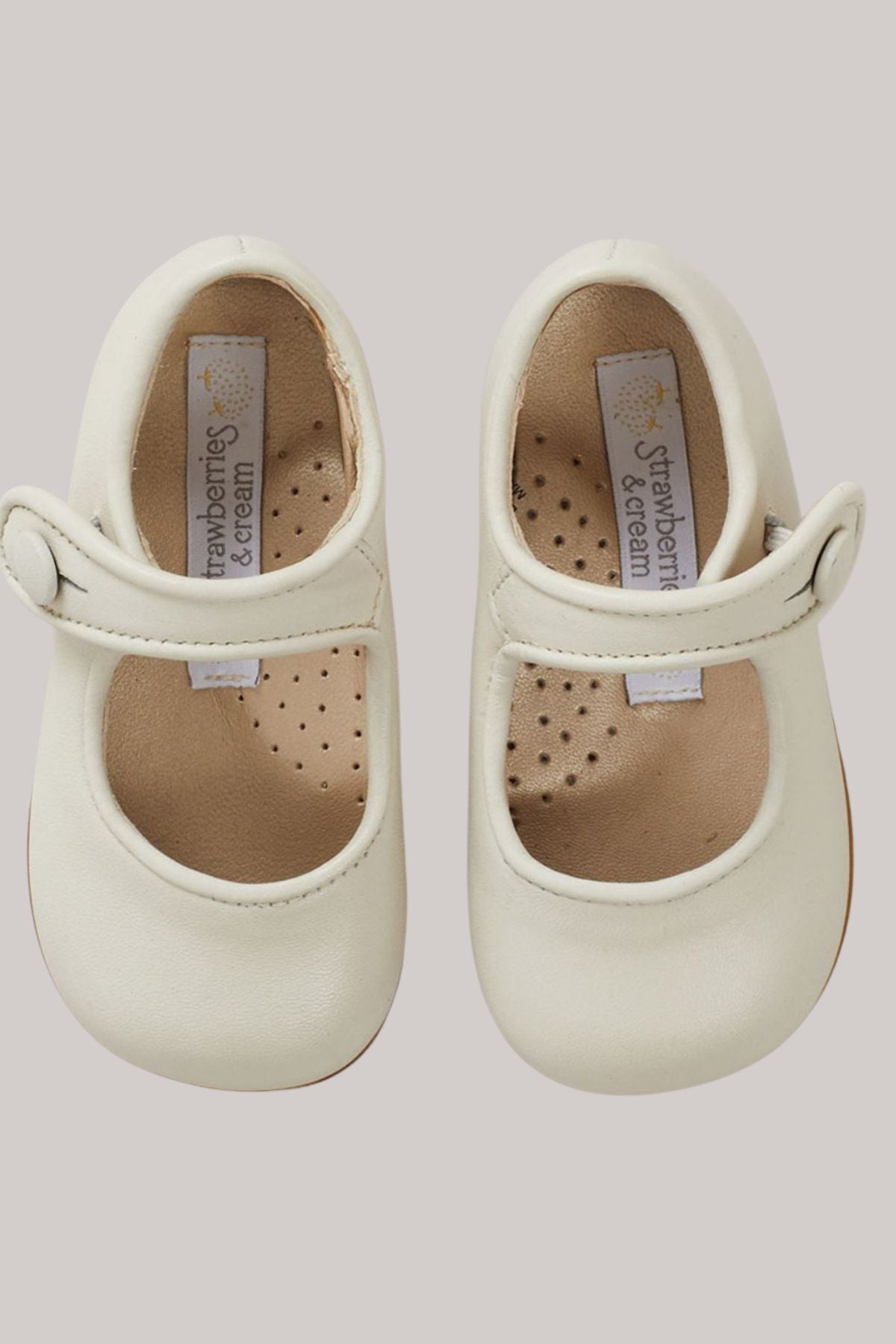 Baby Mary Jane - Ivory - Strawberries & Cream - Ingrid Lewis - Designer 
Pair of cream-coloured baby shoes with 'Strawberries & Cream' label 