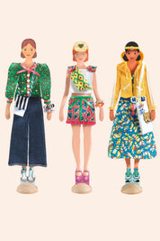Three dolls with colorful outfits on a beige background