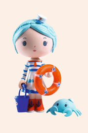 Djeco - Tinyly - Marinette & Scouic doll - Strawberries & Cream - Collectables - Friendship - Dolls - Ingrid Lewis - Designer 
Toy figure with blue hair, striped outfit, and life preserver.