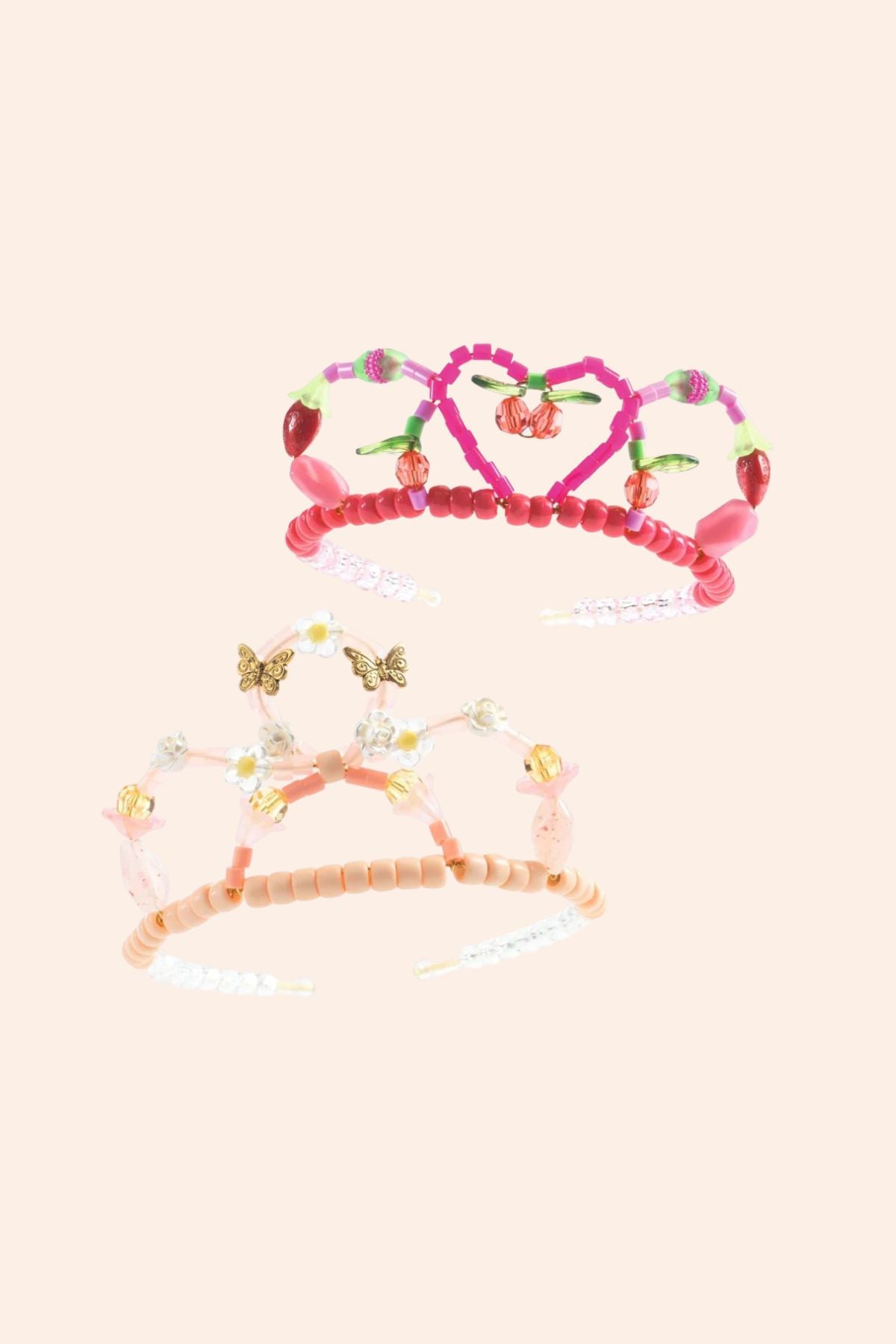 Set of colorful tiaras with decorative elements on a light pink background