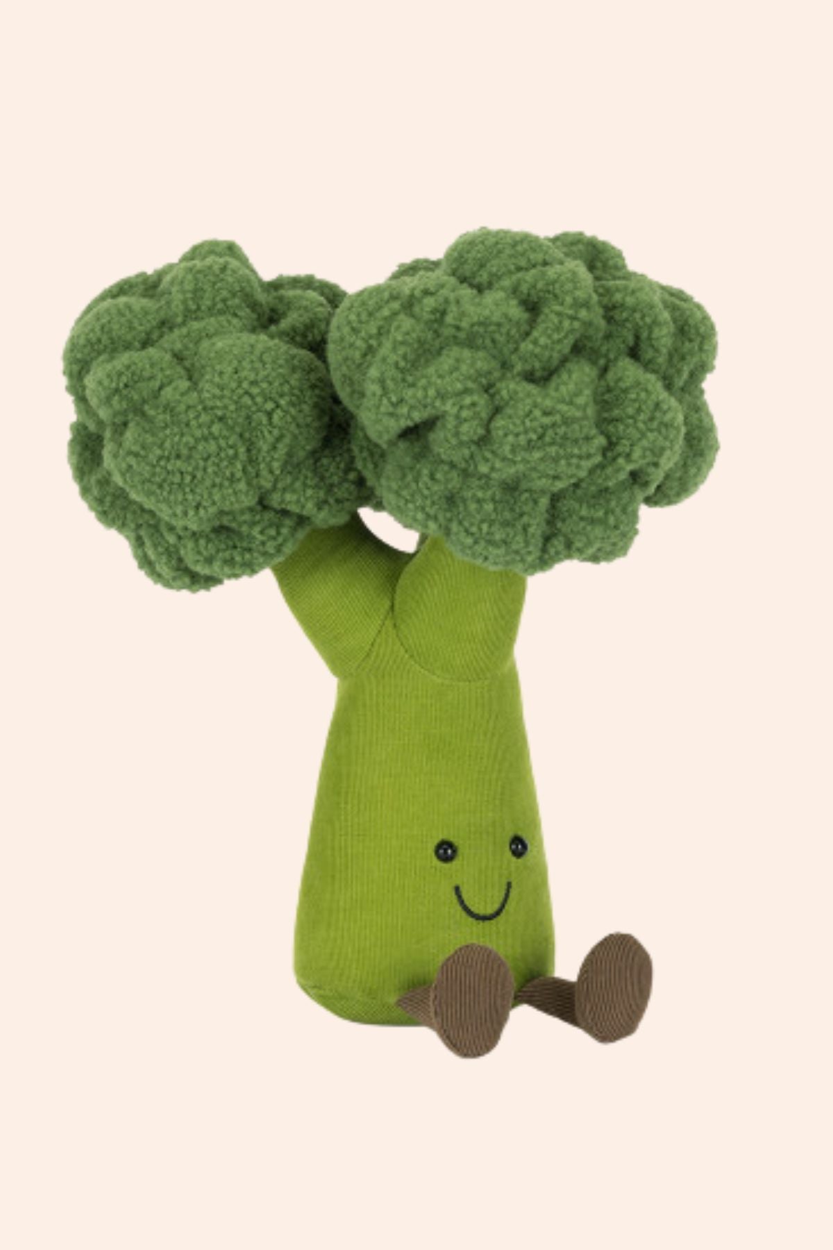 Toy shaped like a broccoli with a smiling face on a beige background