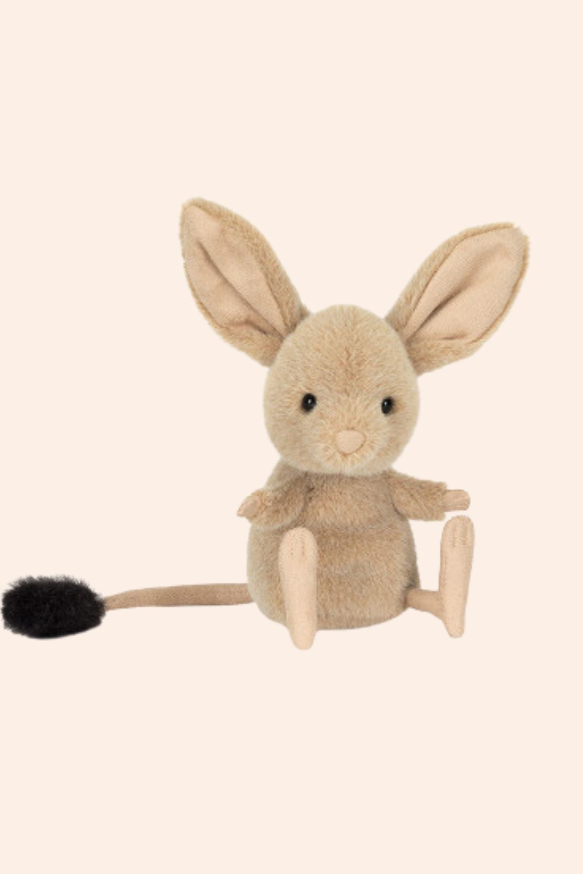 Plush toy mouse with a black tail on a beige background