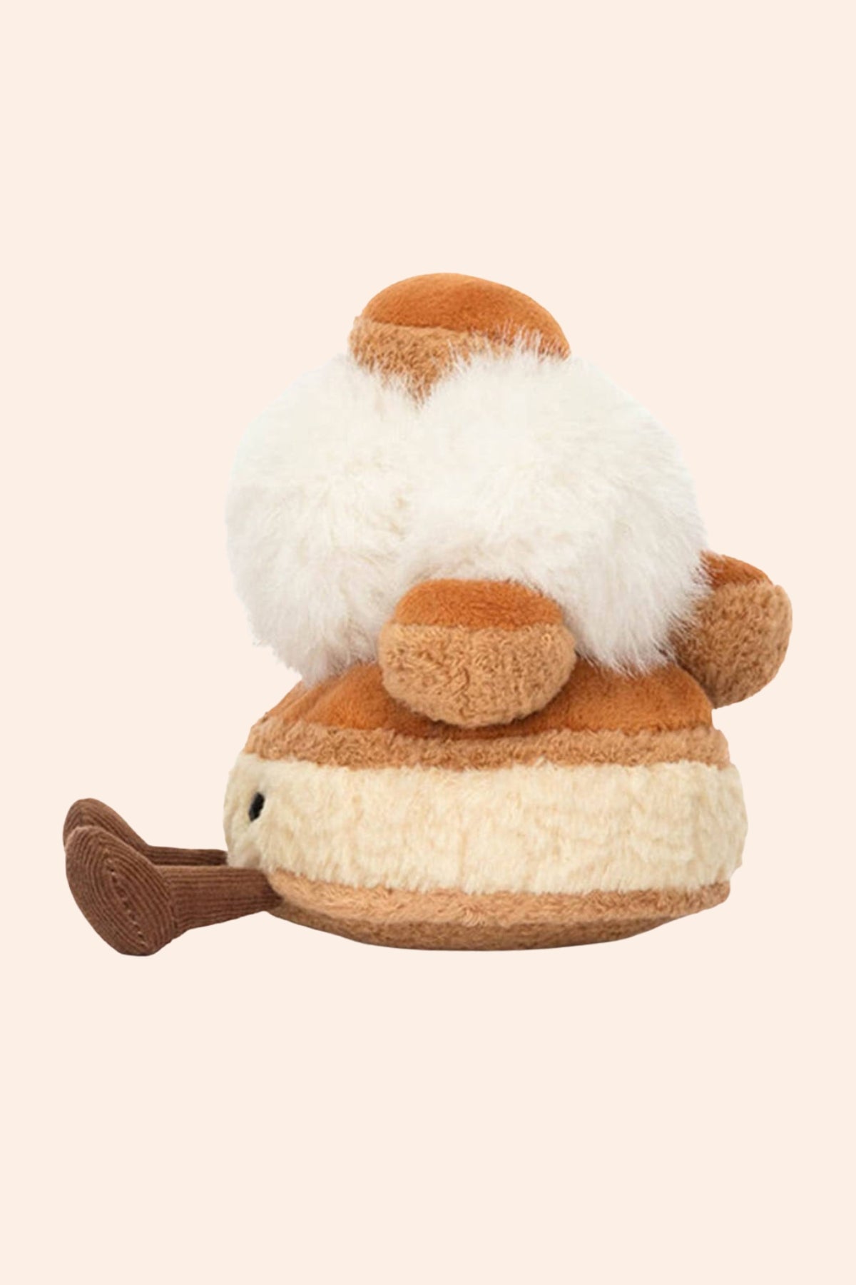Jellycat - Mirielle St. Honoré -  Strawberries & Cream - Ingrid Lewis - Designer
A plush toy shaped like a small patisserie featuring a fluffy white top section, tan and cream horizontal stripes on the lower body, and a brown tail-like extension on the left, shown against a plain light beige background.