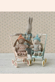 Maileg - Winter Bunny - Micro - Brown Rose - Strawberries & Cream - Ingrid Lewis - Designer
Two toy bunnies in a stroller with a larger toy rabbit standing behind them against a floral wallpaper background.