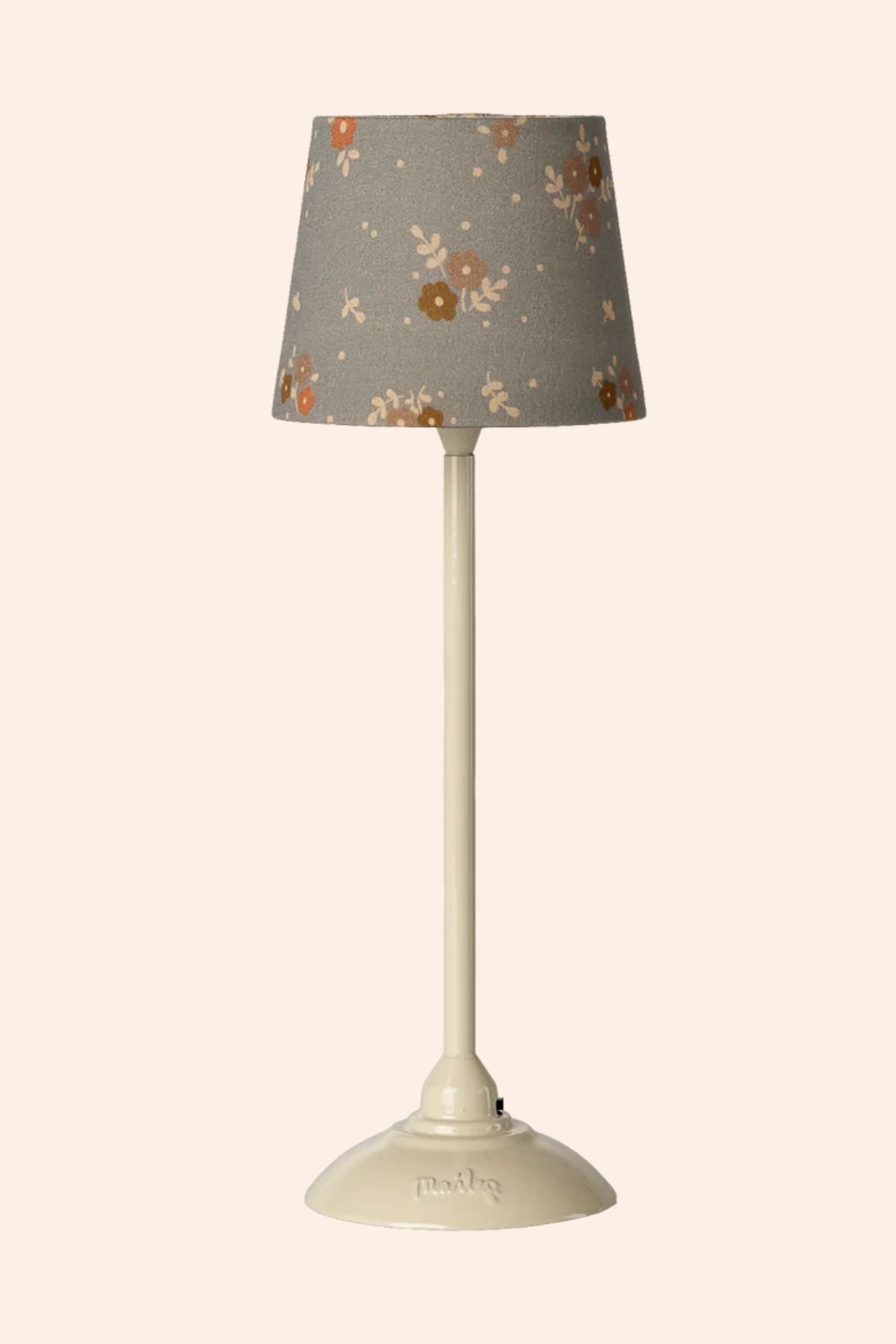 Table lamp with a floral-patterned gray shade on a beige background