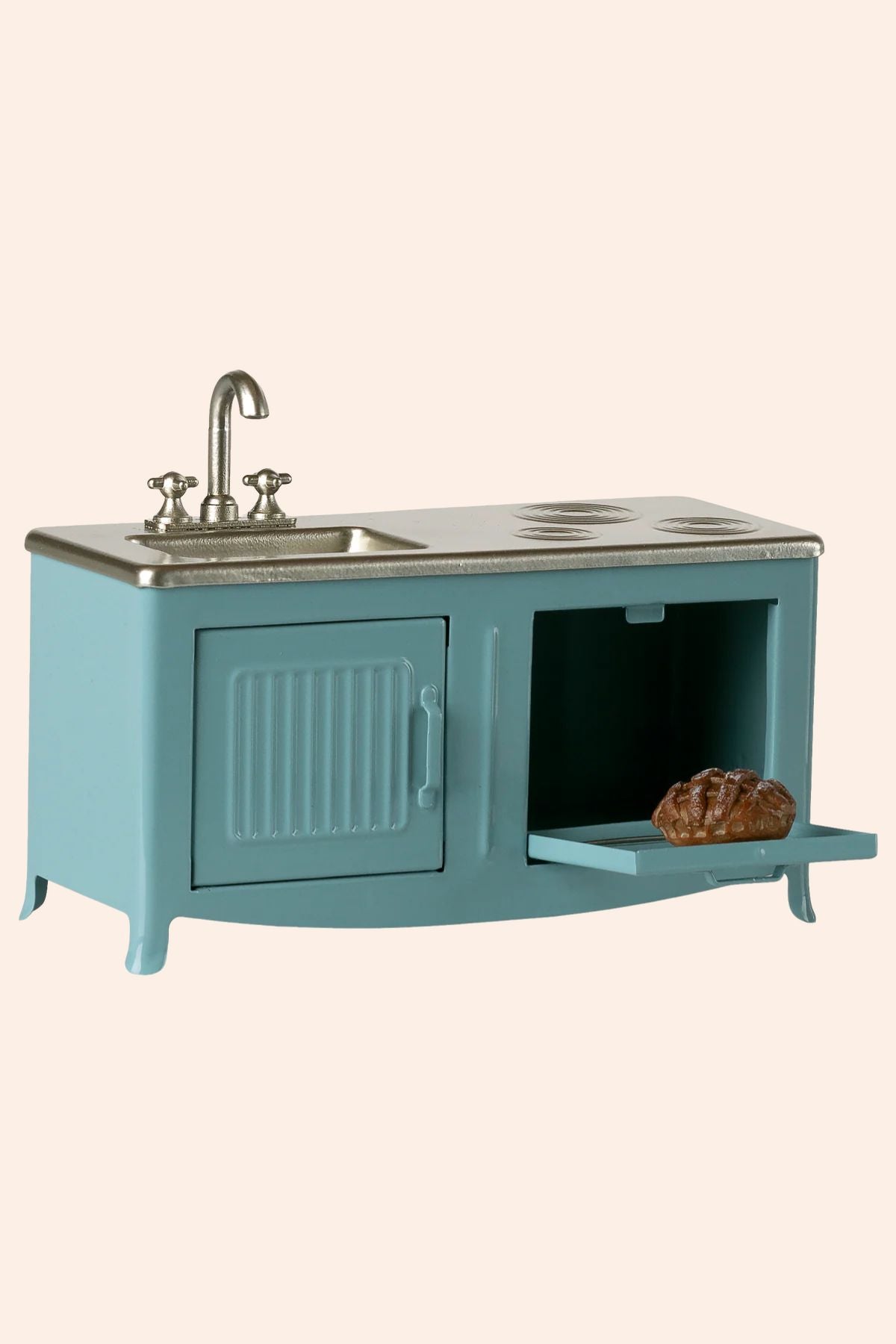 Teal kitchen sink unit with a loaf of bread on a beige background