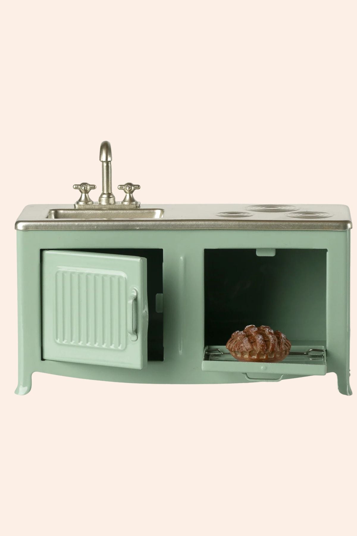 Vintage-style kitchen sink with cabinet and decorative items on a light green background