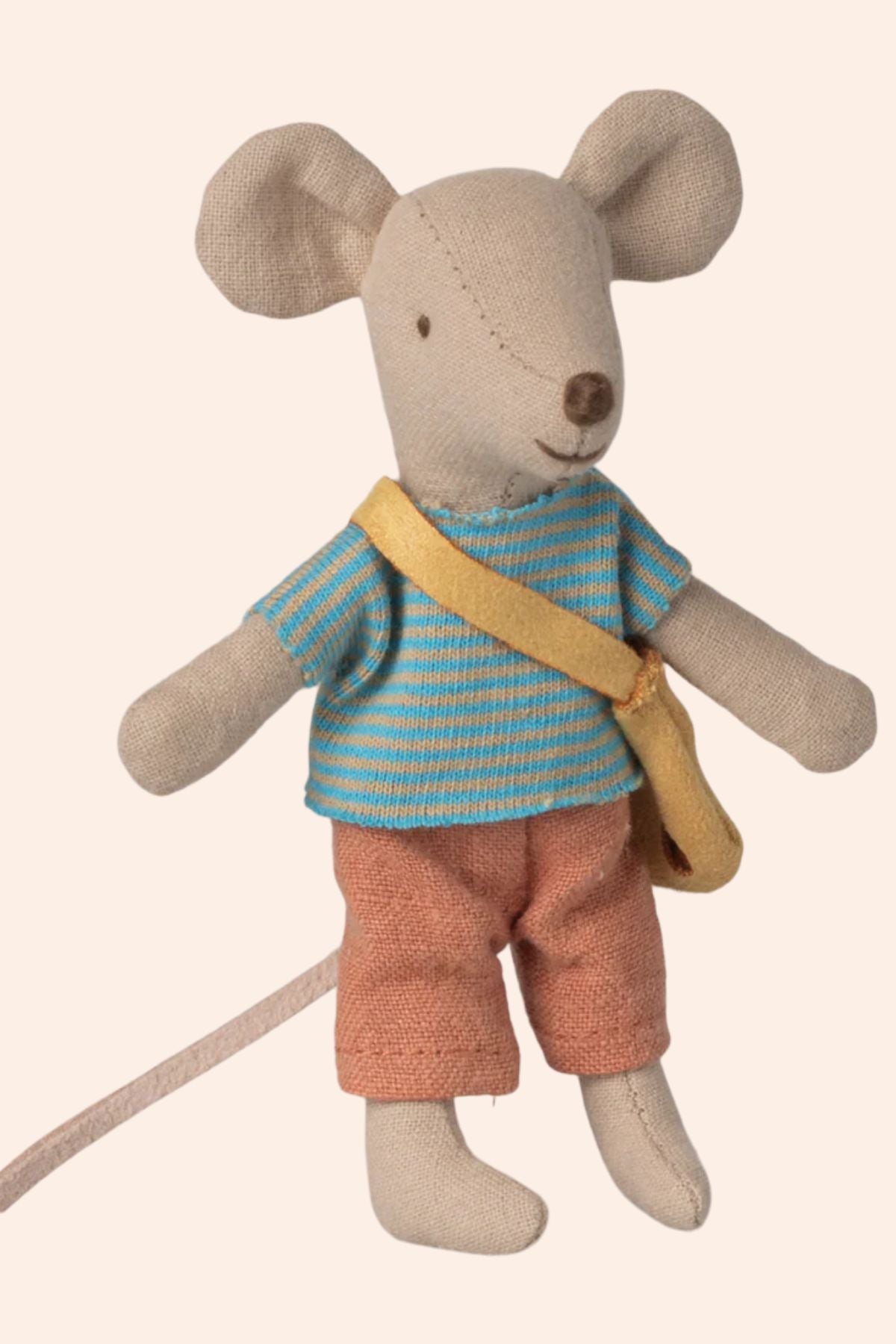 Stuffed toy mouse wearing a striped shirt and shorts with a yellow bag on a beige background