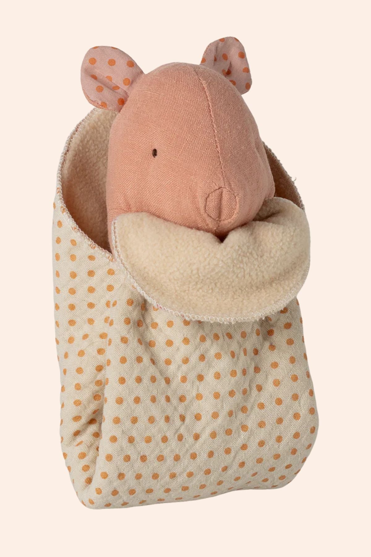 Plush toy in a polka dot bag on a beige background