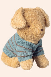 Teddy bear wearing a blue striped sweater on a beige background