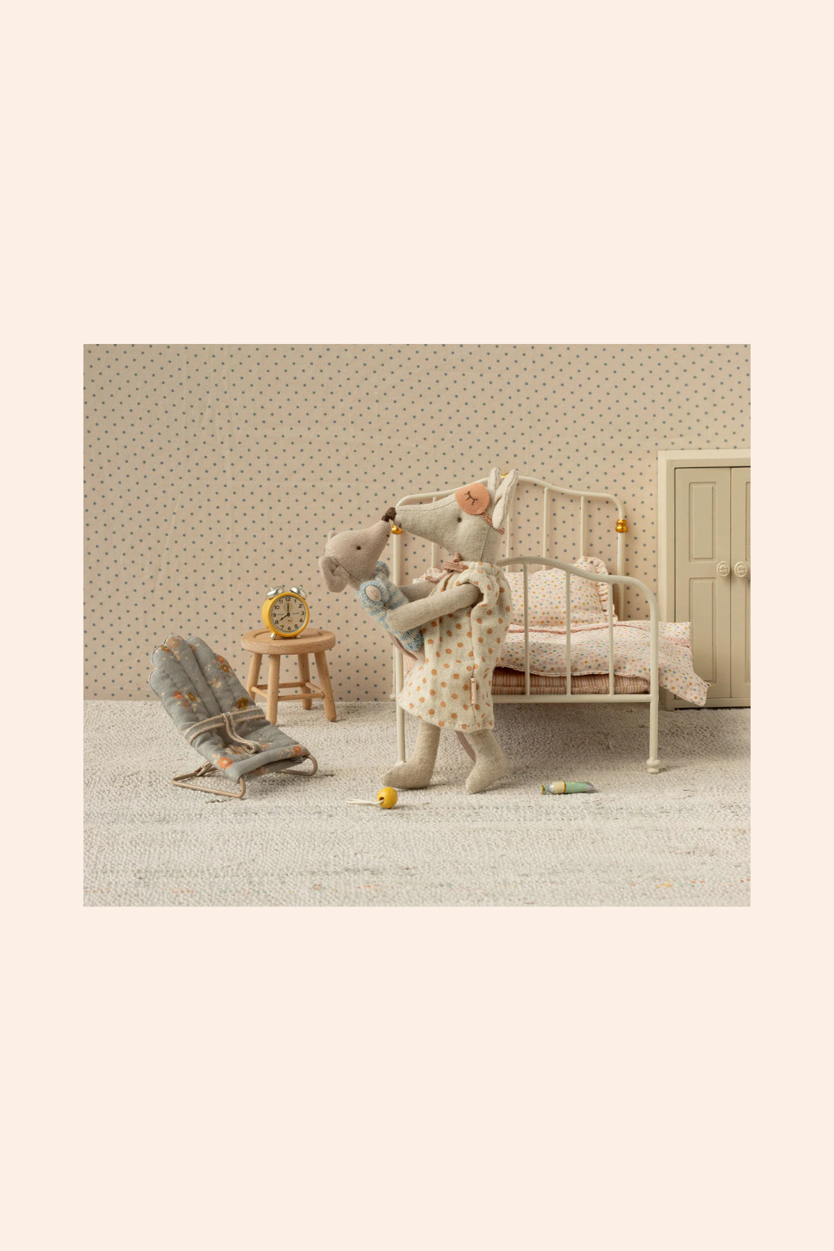 maileg playing with a toy in a room with a crib and rocking chair.