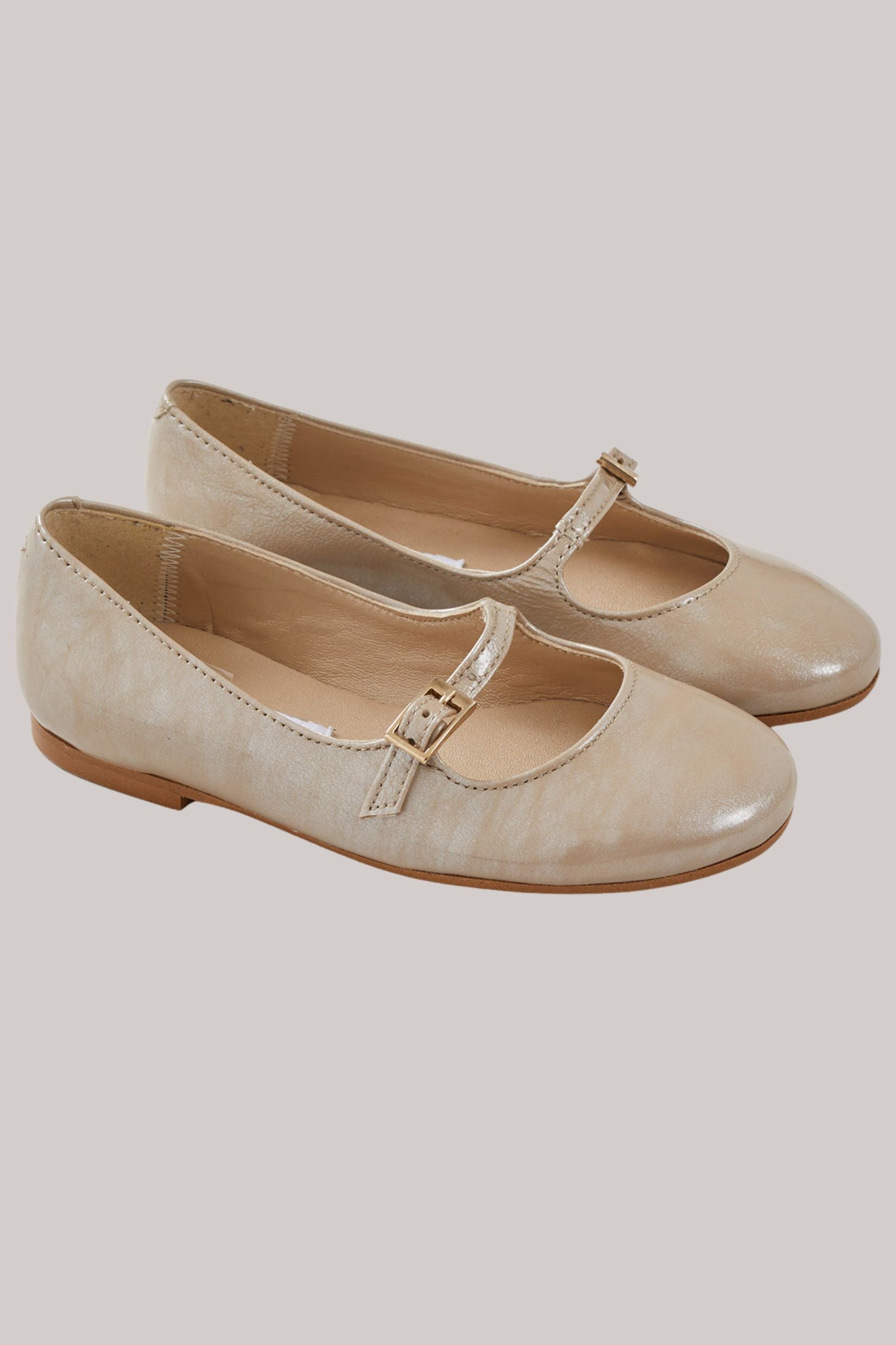 Mary Jane - Patent Leather Beige - Strawberries & Cream - Ingrid Lewis - Designer
Pair of beige shoes with a strap.