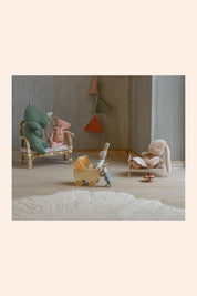 Miniature scene with toys in a room setting, including a baby carriage and chairs.